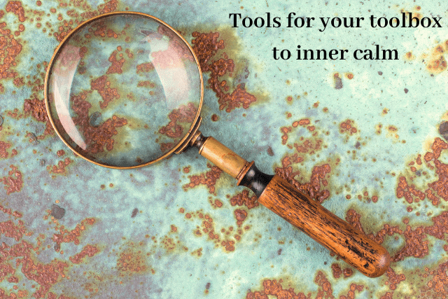 Magnifying glass with wooden handle on rusted metal surface. Text reads: Tools for your toolbox to inner calm.