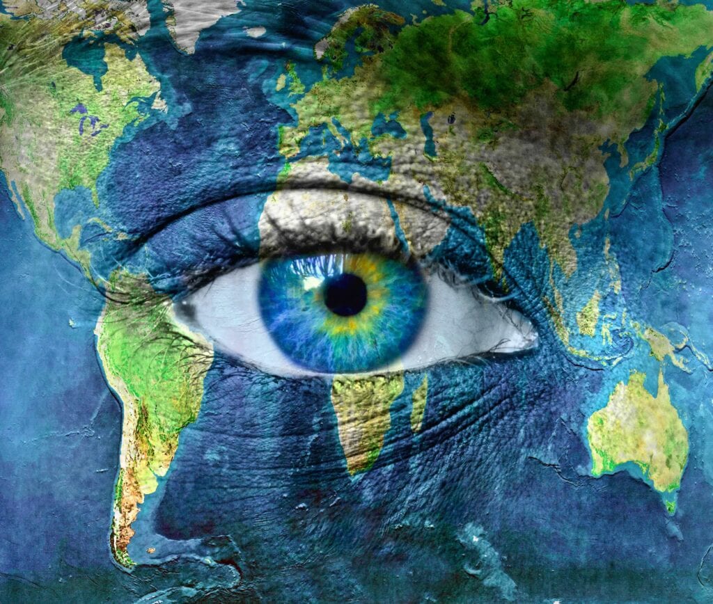 Global map overlayed with a human eye, symbolizing worldwide awareness and focus.