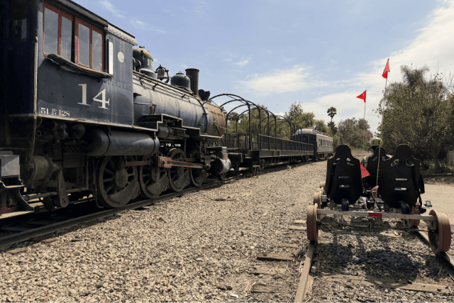 Vintage steam train and old-fashioned rail cart on outdoor tracks at Intentfully Fit.