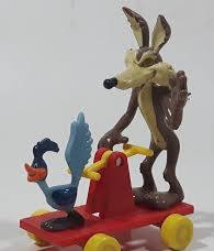 Wile E. Coyote Colorful toy dog and rooster on a red wheeled cart.